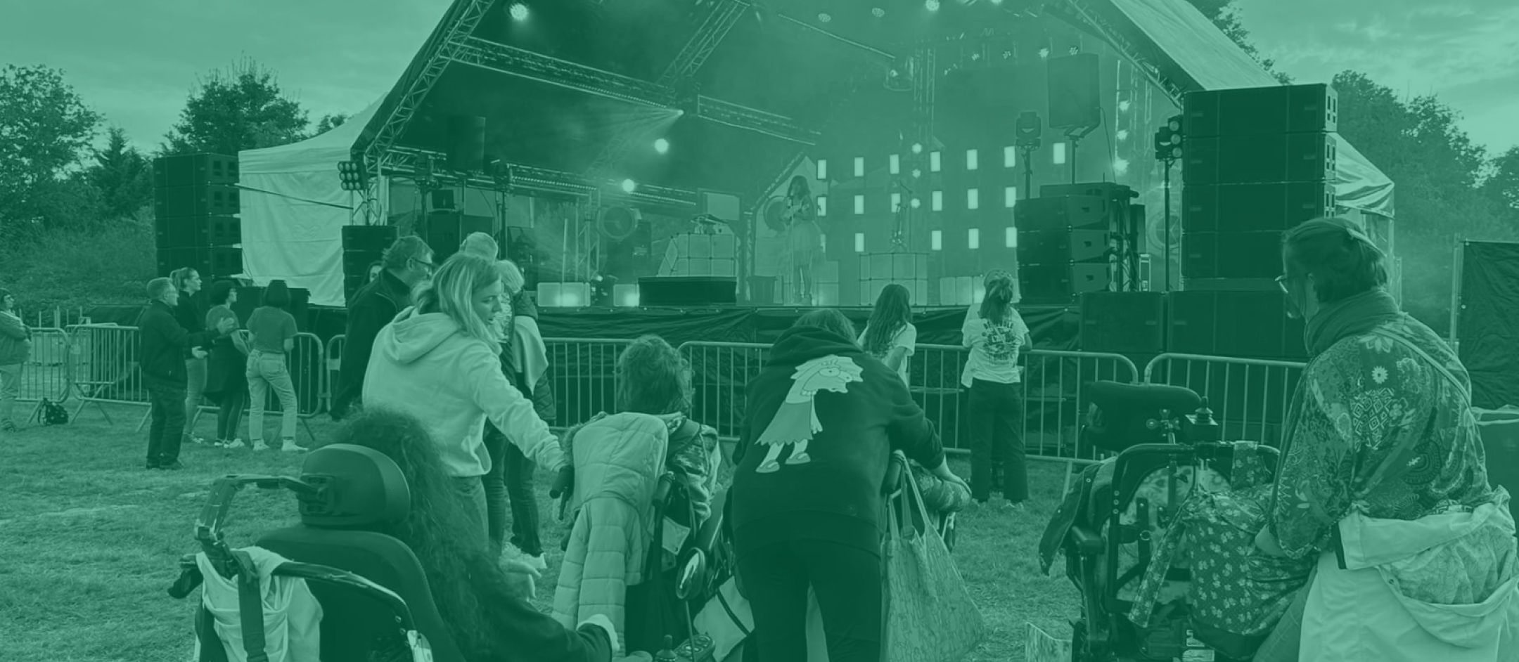 Chanteur reggae aux dreadlocks sur scene devant un public, histoire du reggae en concert en plein air avec drapeaux vert jaune rouge