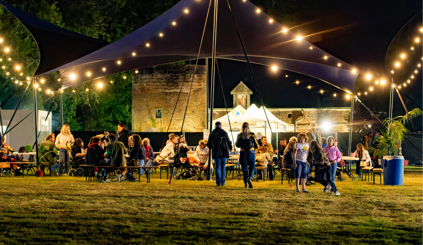 Ambiance conviviale de festival la nuit sous les guirlandes pres du chateau, le reggae vivant en milieu rural du Loiret aujourd hui