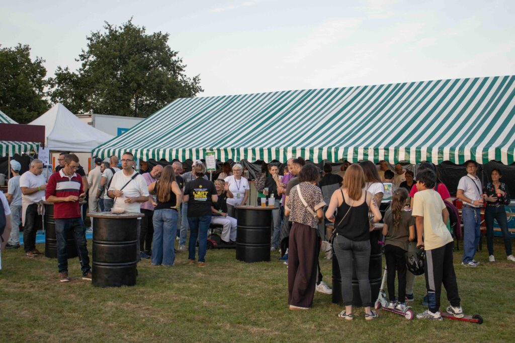 Le site du festival L'Art de Rien en fin de journée Festivaliers sur la pelouse du festival L'Art de Rien près des chapiteaux, un lieu ouvert au public où le chien d'assistance a accès