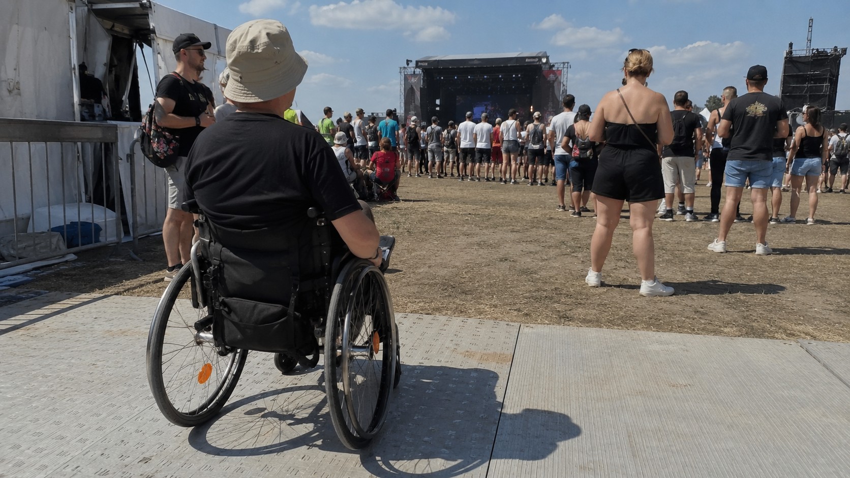 Festivaliers devant une grande scene en plein air, ou le streaming complete la boucle magnetique pour les malentendants